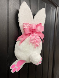 Left Side View of Pink and White Fabric Plush Bunny Butt Wreath with a Pink and White Bow on a Black Door