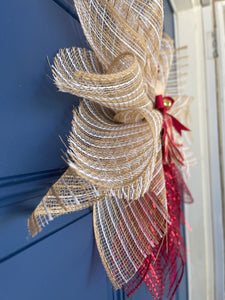 Side View of Rustic Farmhouse Jute Burlap and Red Metallic Angel Tree Topper with Red and Tan Plaid Apron, Red Bow, Gold Bell and Wooden Head on a Blue Door