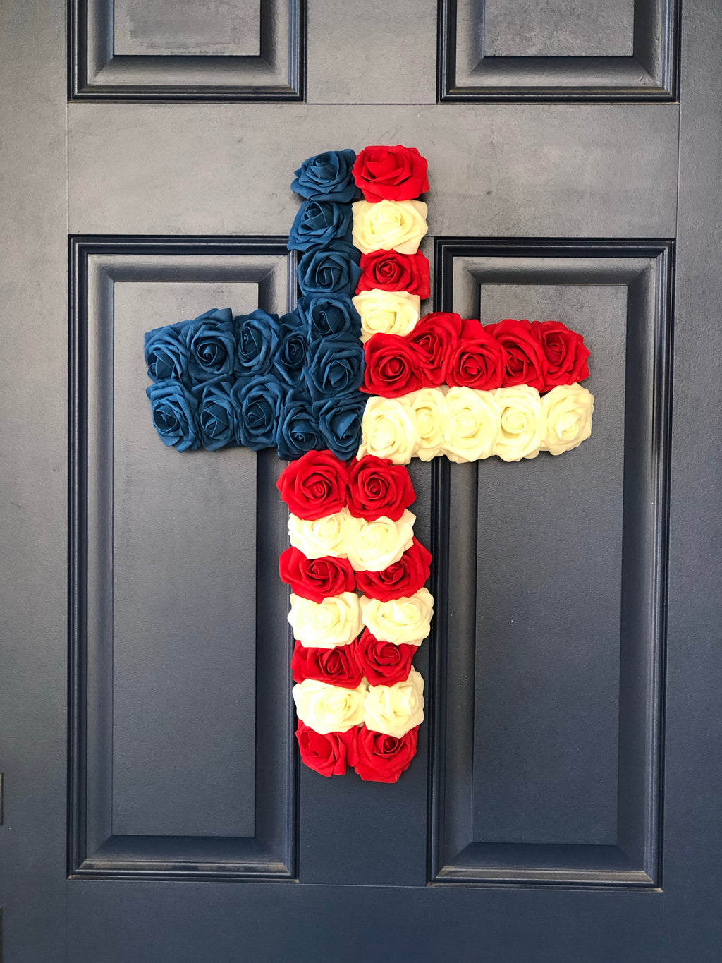 Red, White and Blue Roses in the shape of a cross on a blue door