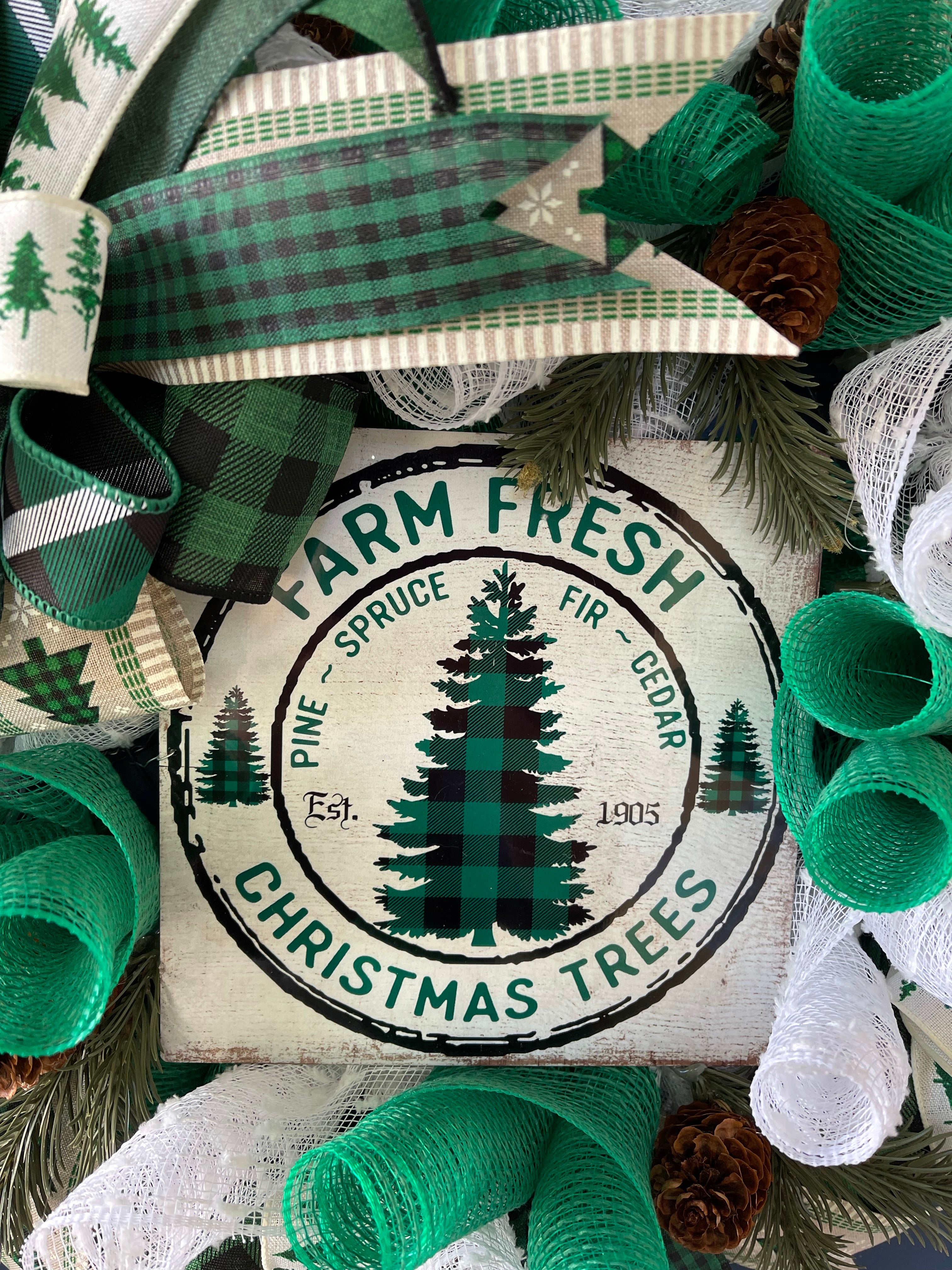 Close up of Farm Fresh Christmas Trees Sign, Featuring Pine, Spruce, Fir and Cedar Established 1905 on wreath