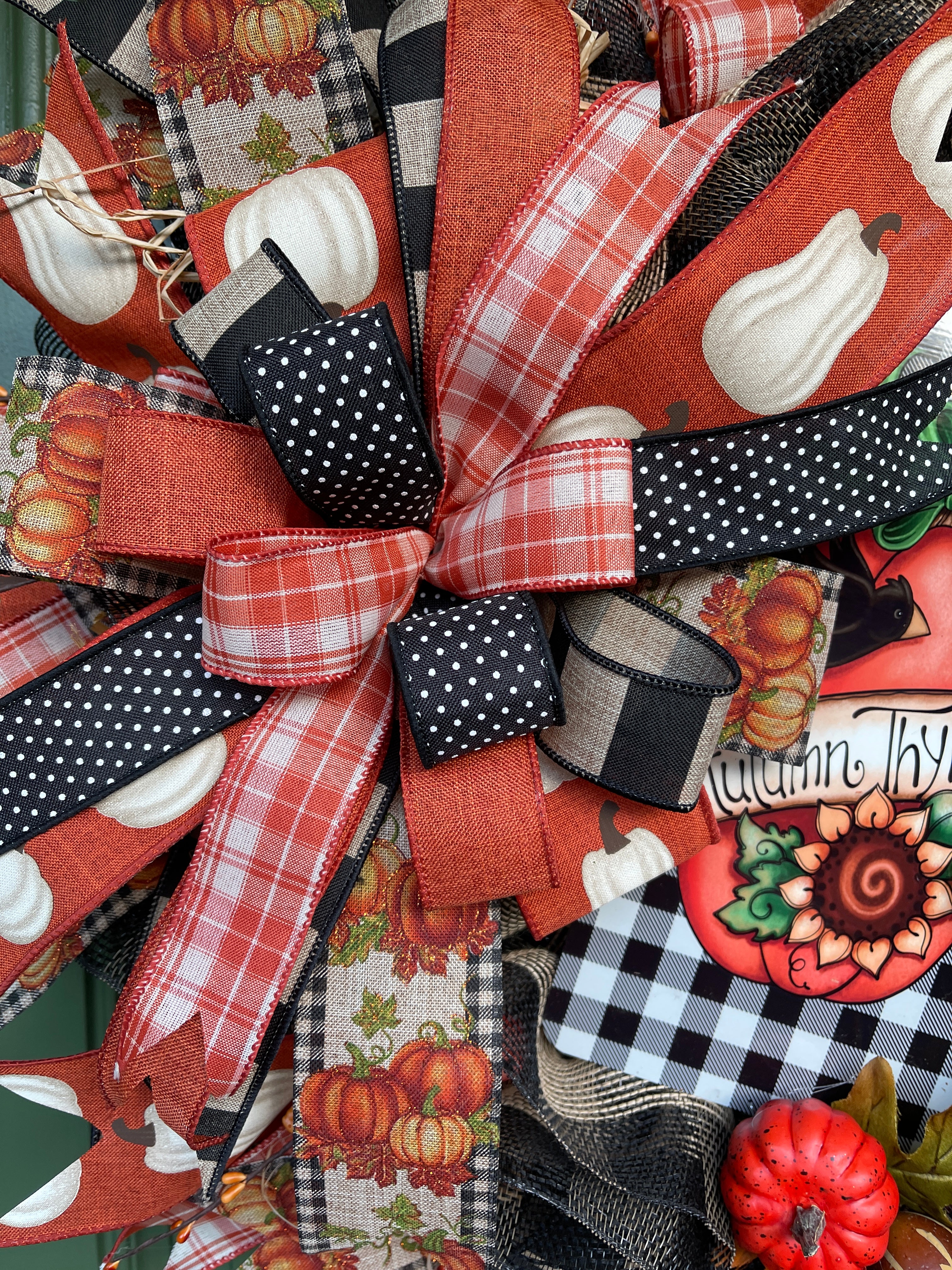 Close Up of Bow with White and Orange Plaid Ribbon, Black with White Polka Dot Ribbon, Pumpkin Prints on Natural and Orange ribbons on a Fall Wreath
