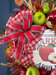 Close up of Upper Bow of Red, White and Black Ribbons, Small and Large Red and Green Apples, Fall Leaves and Berries on Grapevine Wreath