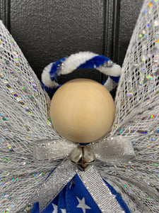 Close Up View of Blue, white and silver deco mesh angel with blue ribbon with white stars, wooden head, silver bow and bell with blue and white halo on a black door. 