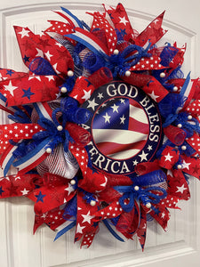 Left Side View of Red, White and Blue Stars and Stripes, God Bless America Deco Mesh Wreath on a White Door