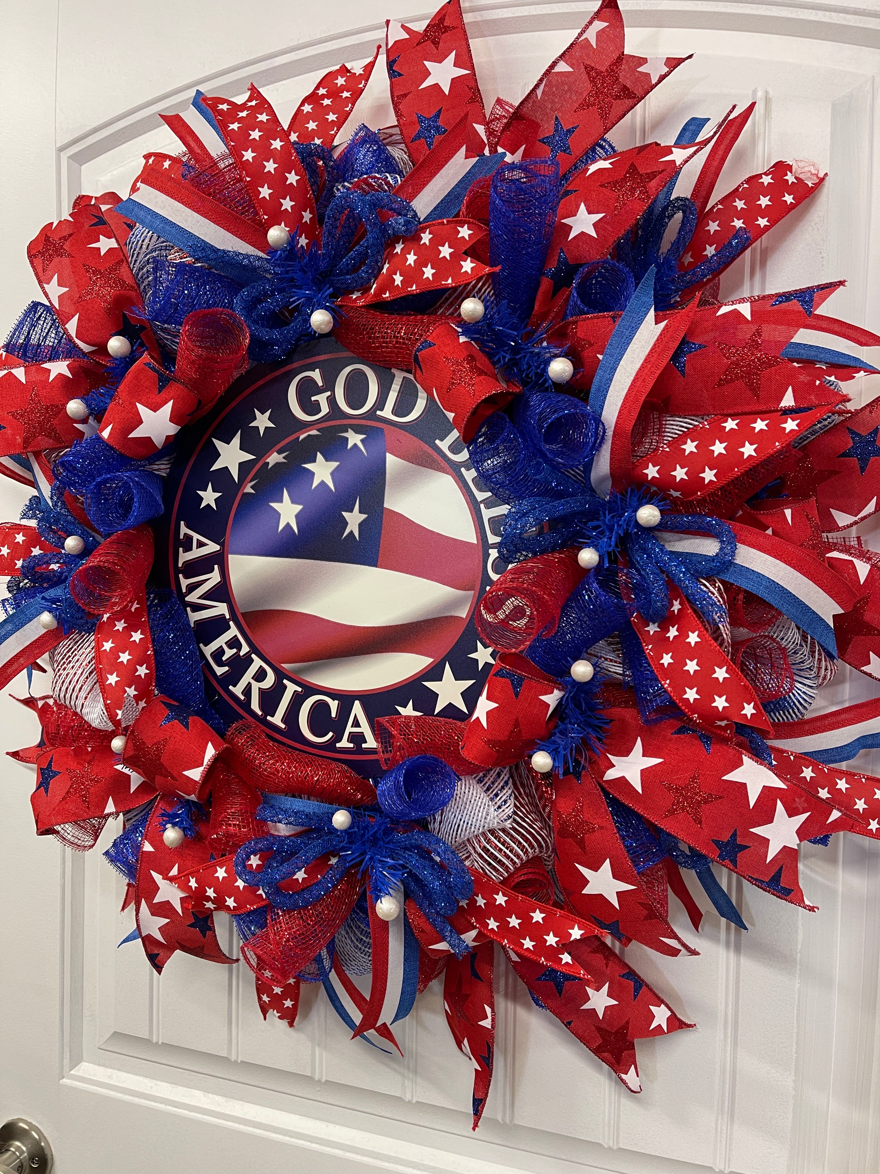 Right Side View of Red, White and Blue Stars and Stripes, God Bless America Deco Mesh Wreath on a White Door