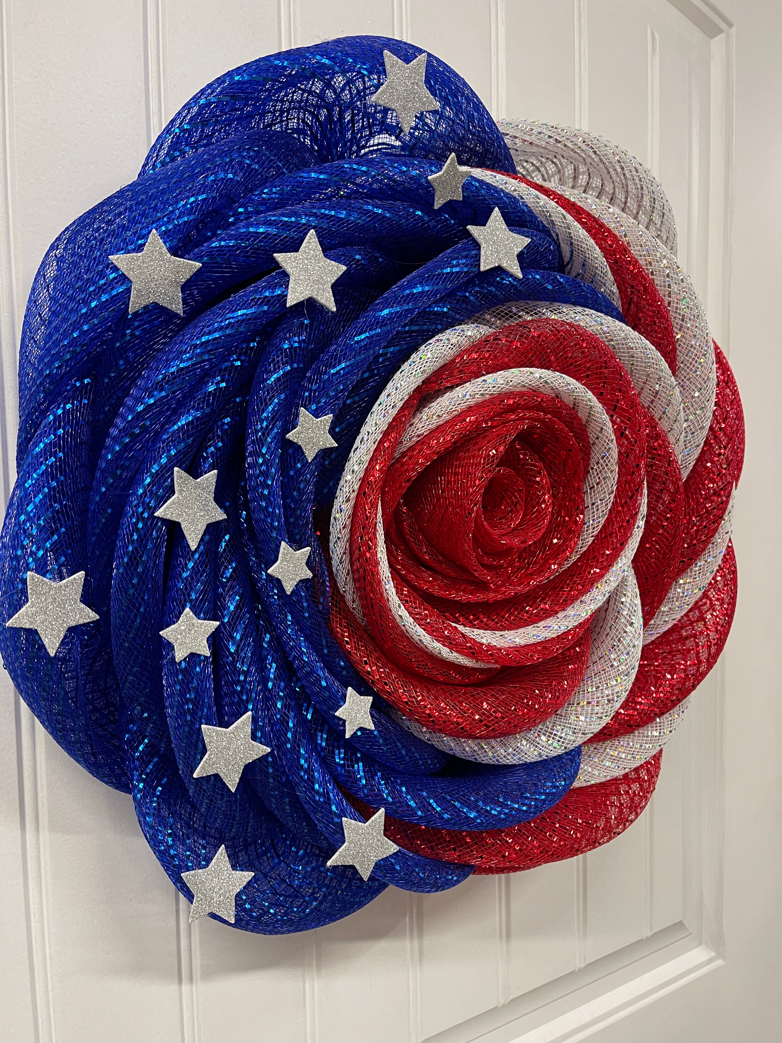 Left Side View of Red, White and Blue Deco Mesh Rose Flower Wreath with Silver Stars on a White Door
