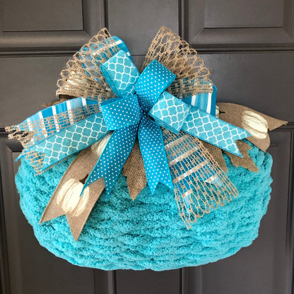 Blue Chenille Yarn Pumpkin Wreath with Blue, White and Beige Bow at the top on a Gray Door. 