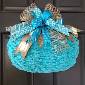 Blue Chenille Yarn Pumpkin Wreath with Blue, White and Beige Bow at the top on a Gray Door. 