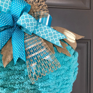 Close Up of Bow featuring Blue, White and Tan Ribbons on a Chenille Yarn Pumpkin Wreath. 