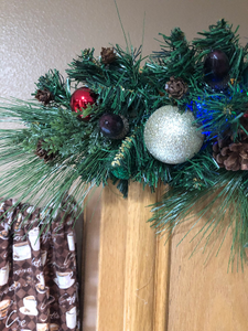 the tapered end of the evergreen swag featuring glitter Christmas balls, 