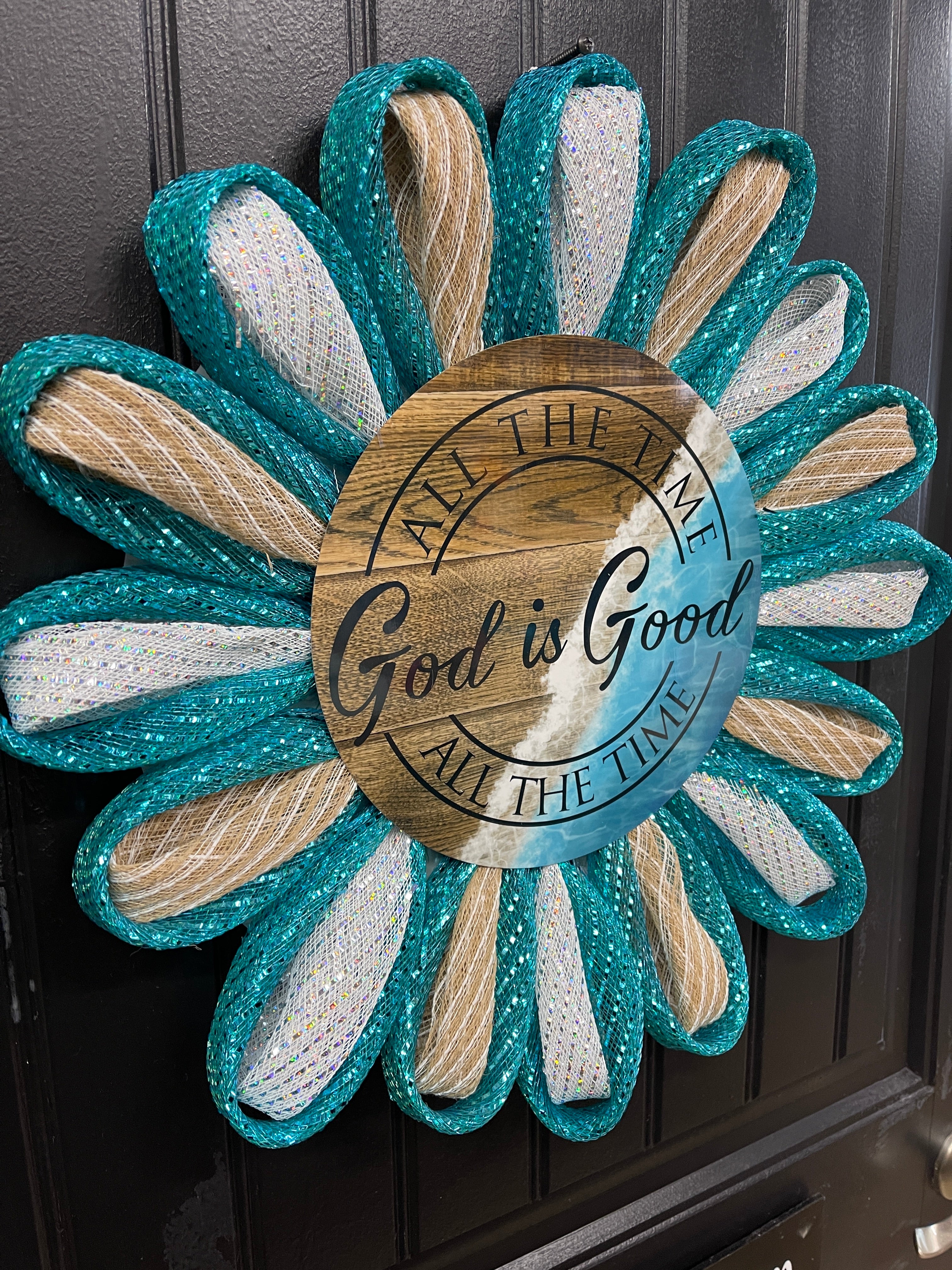 Left Side View of Teal, White and Beige Deco Mesh Daisy Chain Petal Wreath with a Sign that reads, "All the Time God is Good" on a black door.