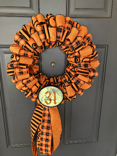 Top View of Black and Orange Ribbon October 31st Halloween Wreath on Gray Door