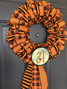 Left Side View of Black and Orange Ribbon October 31st Halloween Wreath on Gray Door