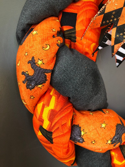 Close Up of Orange and Black Fabric Braided and Stuffed Featuring Pumpkins, Black Cats and Moons