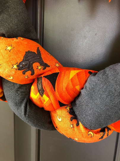 Close Up of Orange and Black Fabric Braided and Stuffed Featuring Pumpkins, Black Cats and Moons