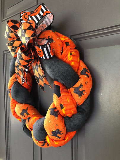 Right Side View of Orange and Black Plush Fabric Wreath with Orange, Black and White Ribbons on a Bow 