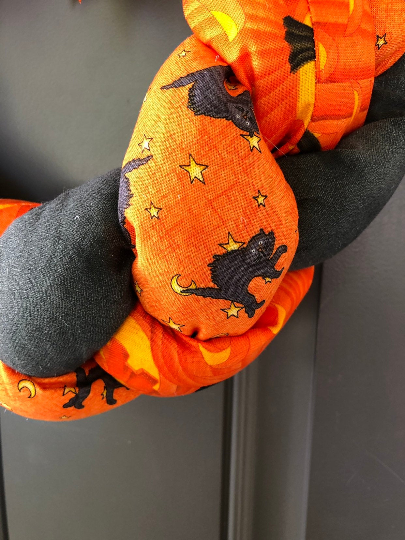 Close Up of Orange and Black Fabric Braided and Stuffed Featuring Pumpkins, Black Cats and Moons