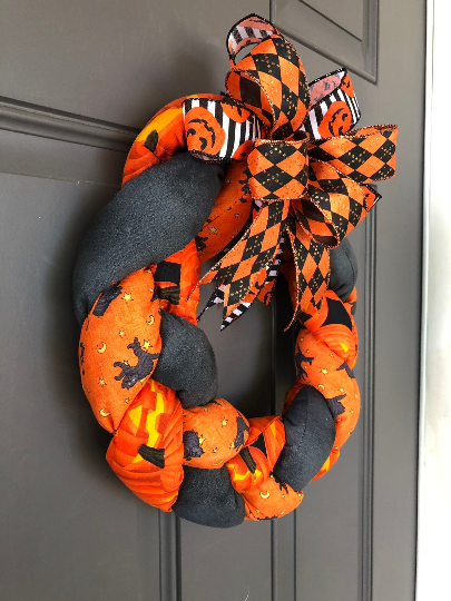 Left Side View of Orange and Black Plush Fabric Wreath with Orange, Black and White Ribbons on a Bow