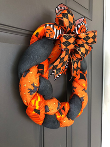 Left Side View of Orange and Black Plush Fabric Wreath with Orange, Black and White Ribbons on a Bow