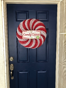 candy cane Christmas red and white peppermint wreath hanging on door