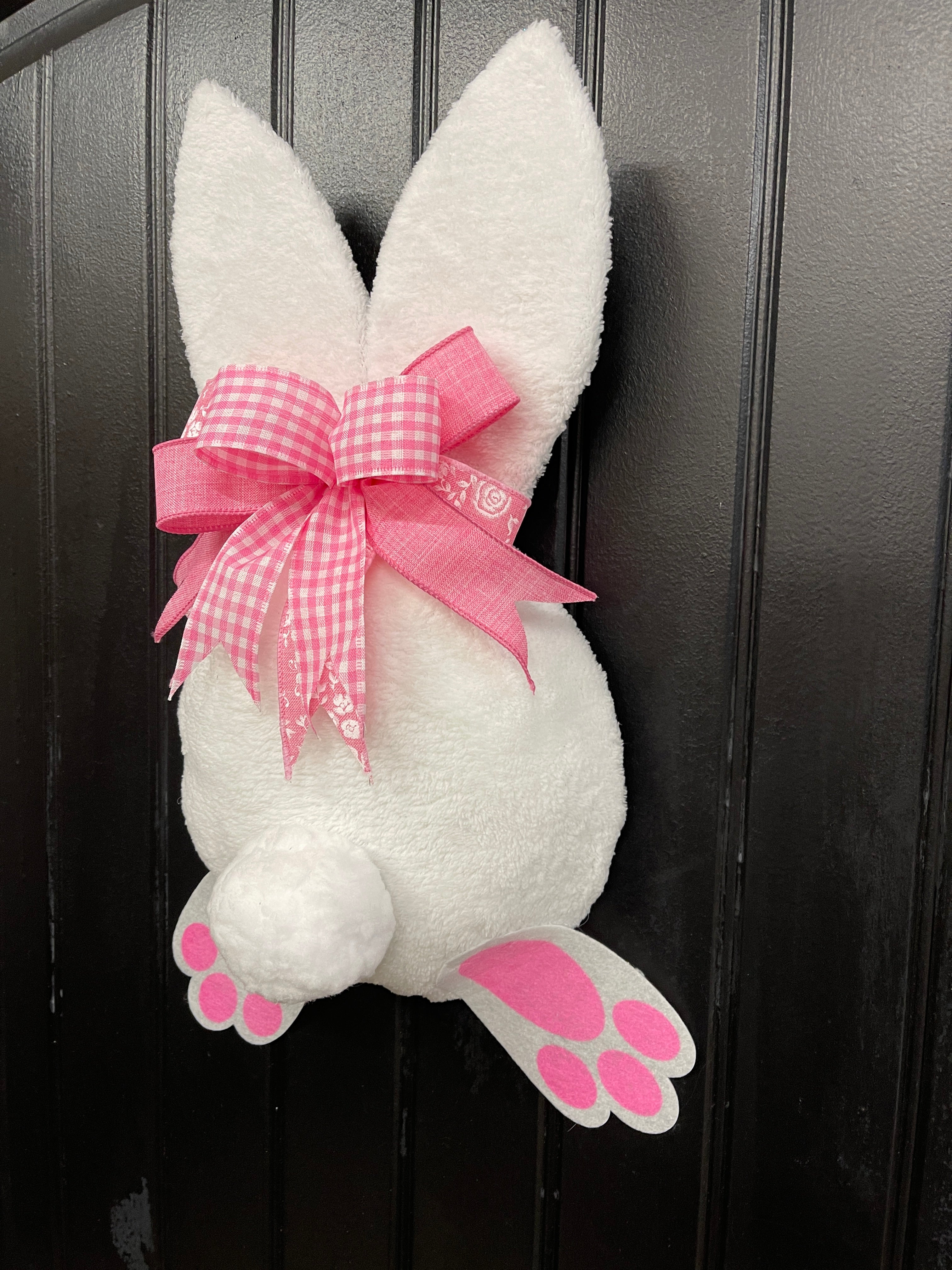 Right Side View of Pink and White Fabric Plush Bunny Butt Wreath with a Pink and White Bow on a Black Door