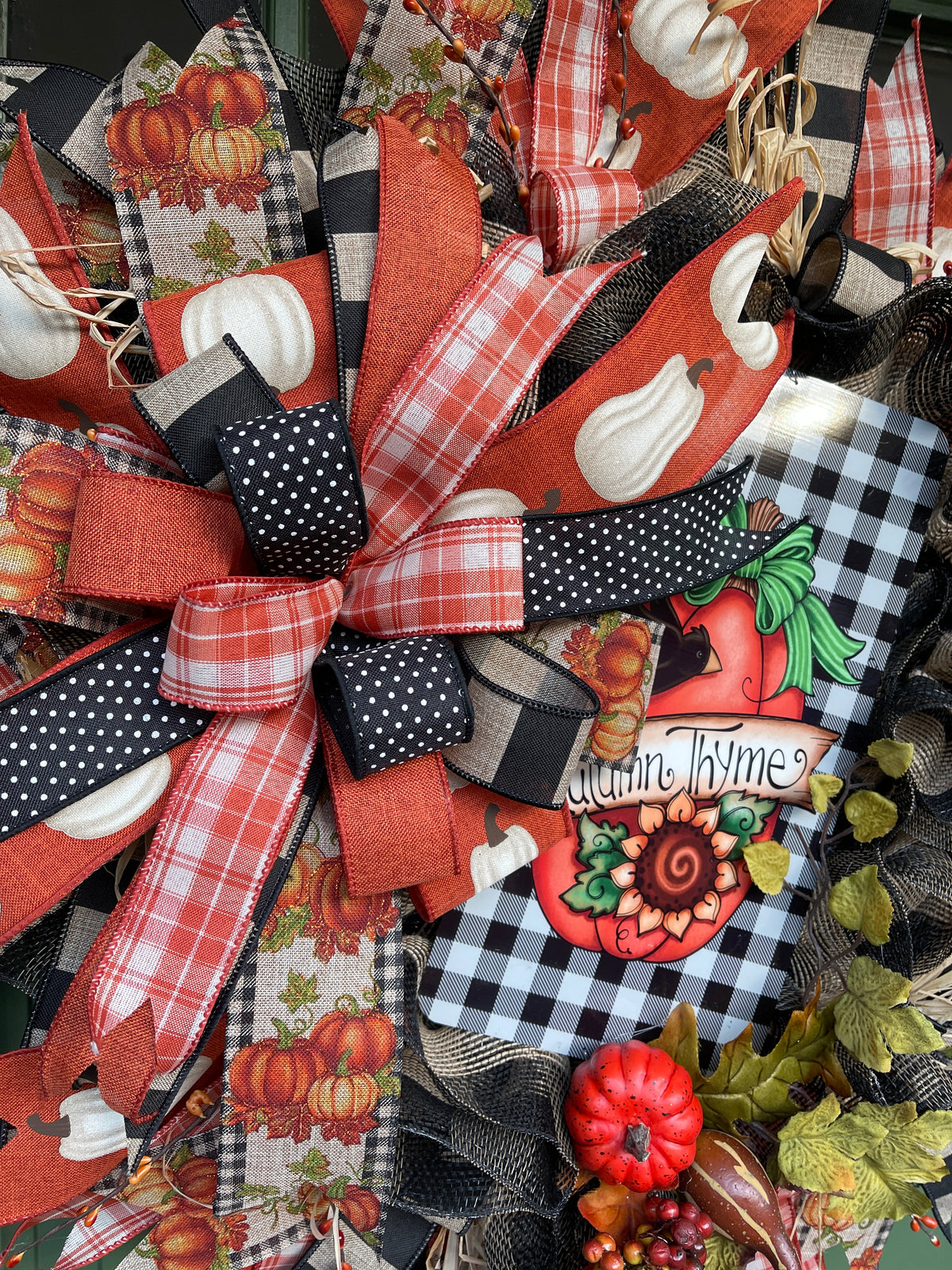 Close Up Details of Fall Bow featuring Black, White, Orange and Tan Ribbons, Autumn Thyme Sign and Artificial Pumpkins and Squash on a Fall Wreath