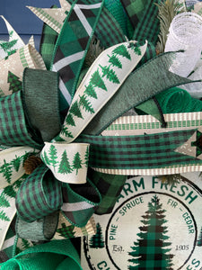 Close Up of Ribbons in the Bow featuring pine trees on white, along with various prints of black, white and Green plaid and gingham ribbons