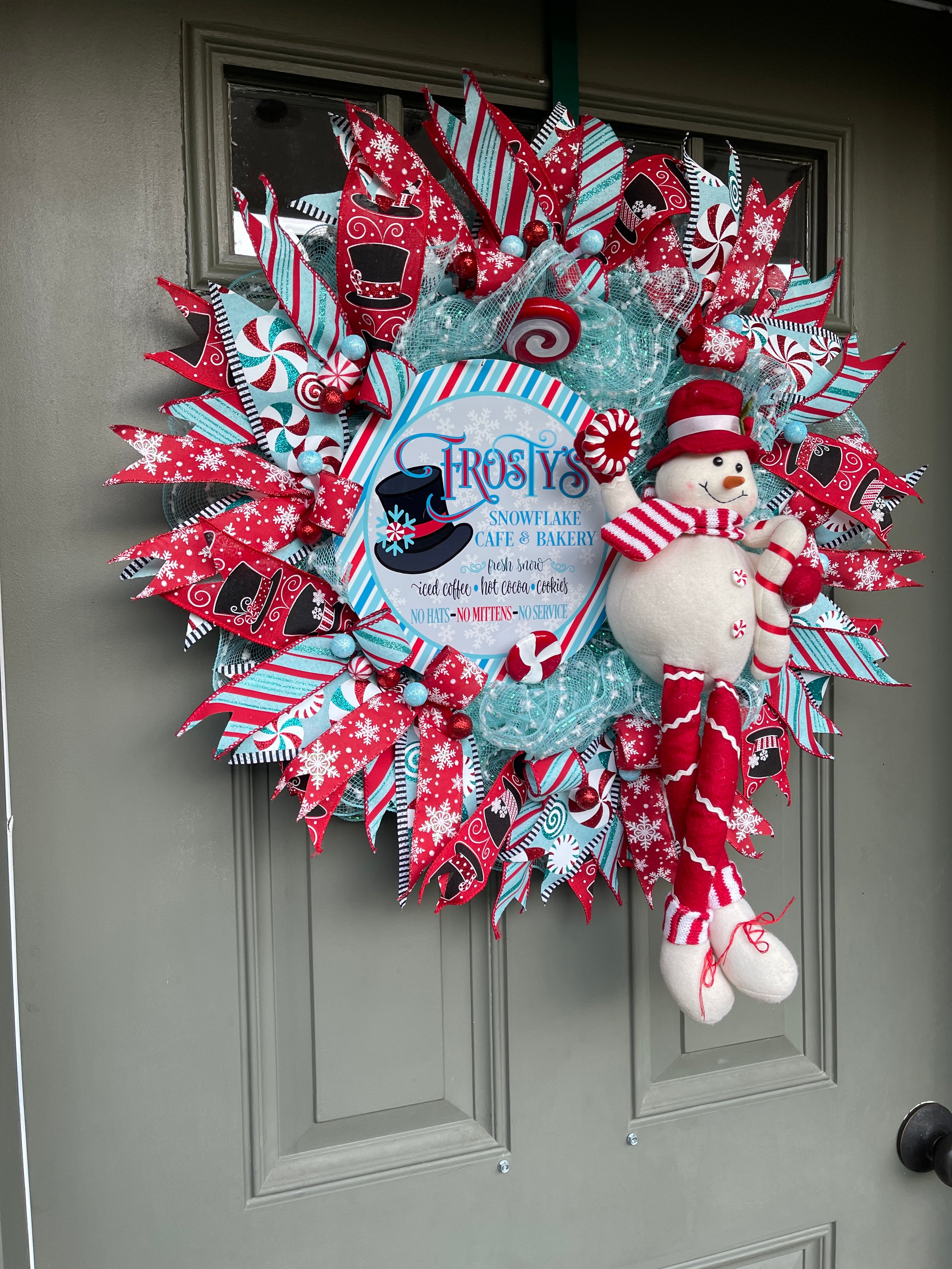 Left Side View of Red, White and Blue Winter Frosty the Snowman Deco Mesh Wreath with Peppermint Candy and Plush Snowman on a Green Door.