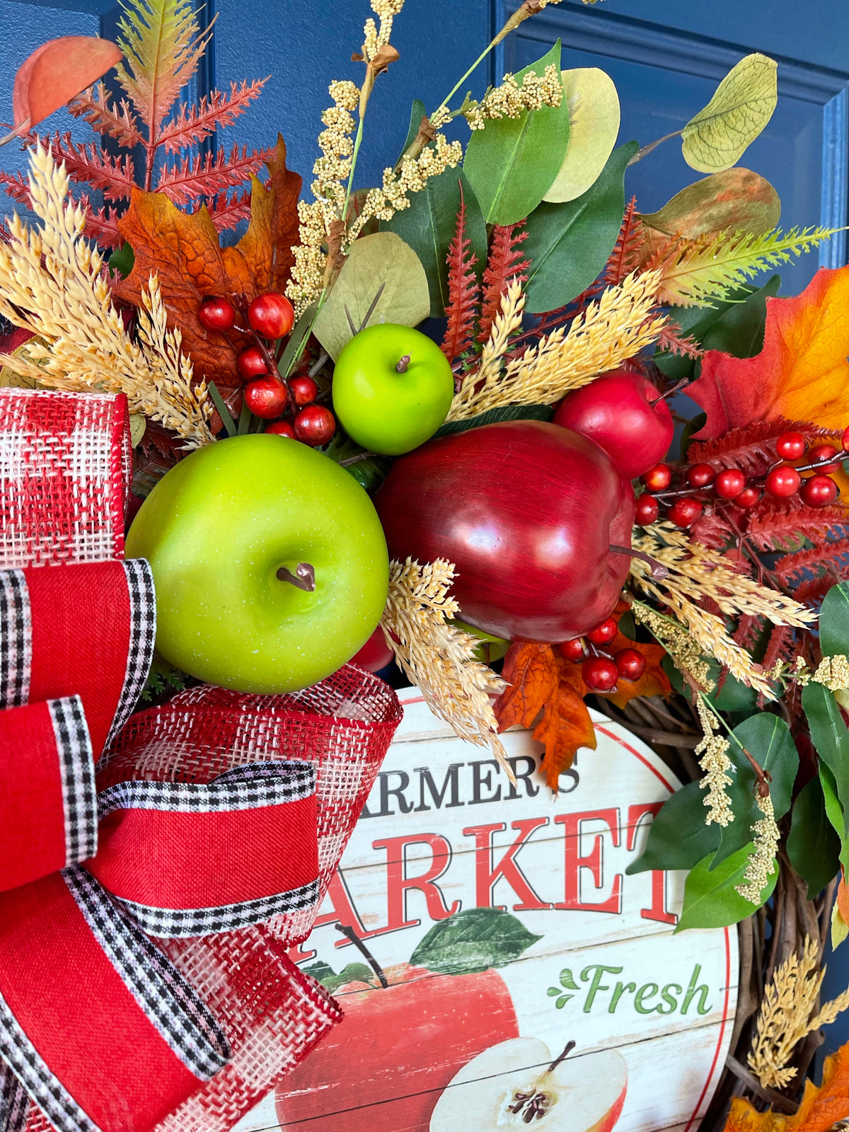 Close up of Artificial Florals, Fruits, Leaves and Berries on a Grapevine Wreath for Fall