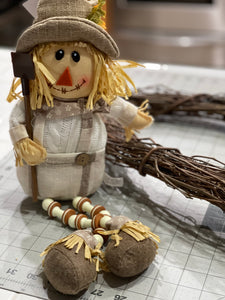 White and Tan Plush Scarecrow wearing overalls holding a shovel 