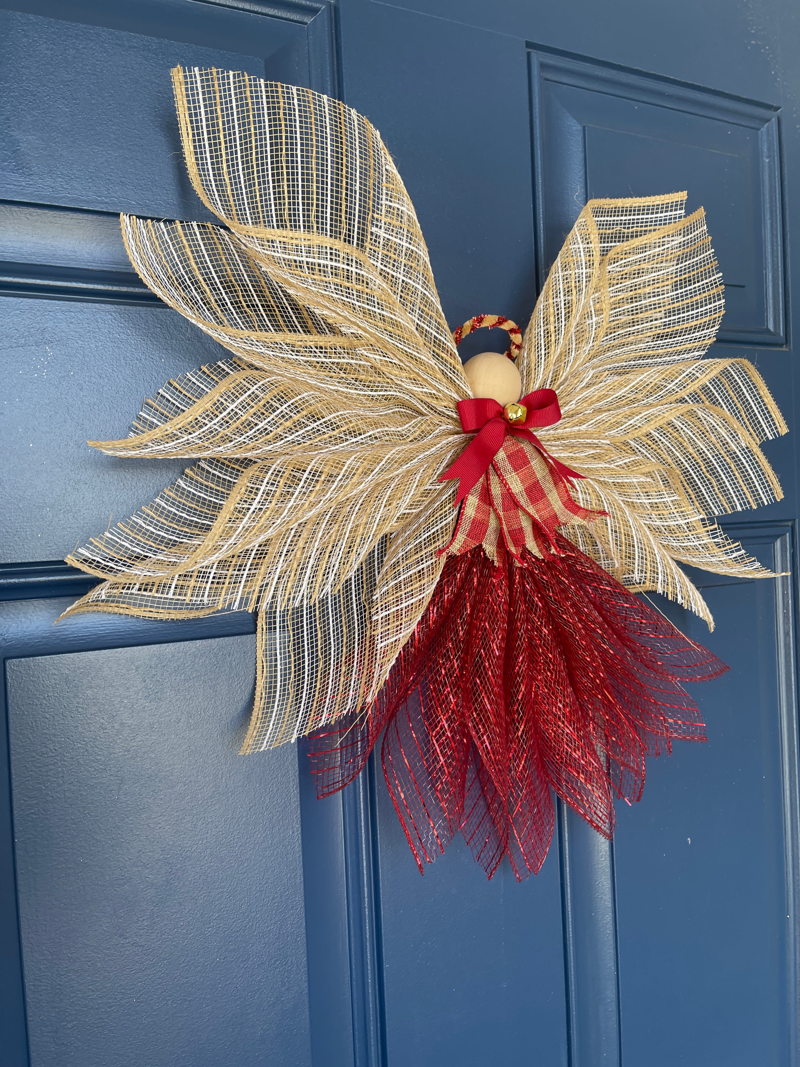 Left Side View of Rustic Farmhouse Jute Burlap and Red Metallic Angel Tree Topper with Red and Tan Plaid Apron, Red Bow, Gold Bell and Wooden Head on a Blue Door