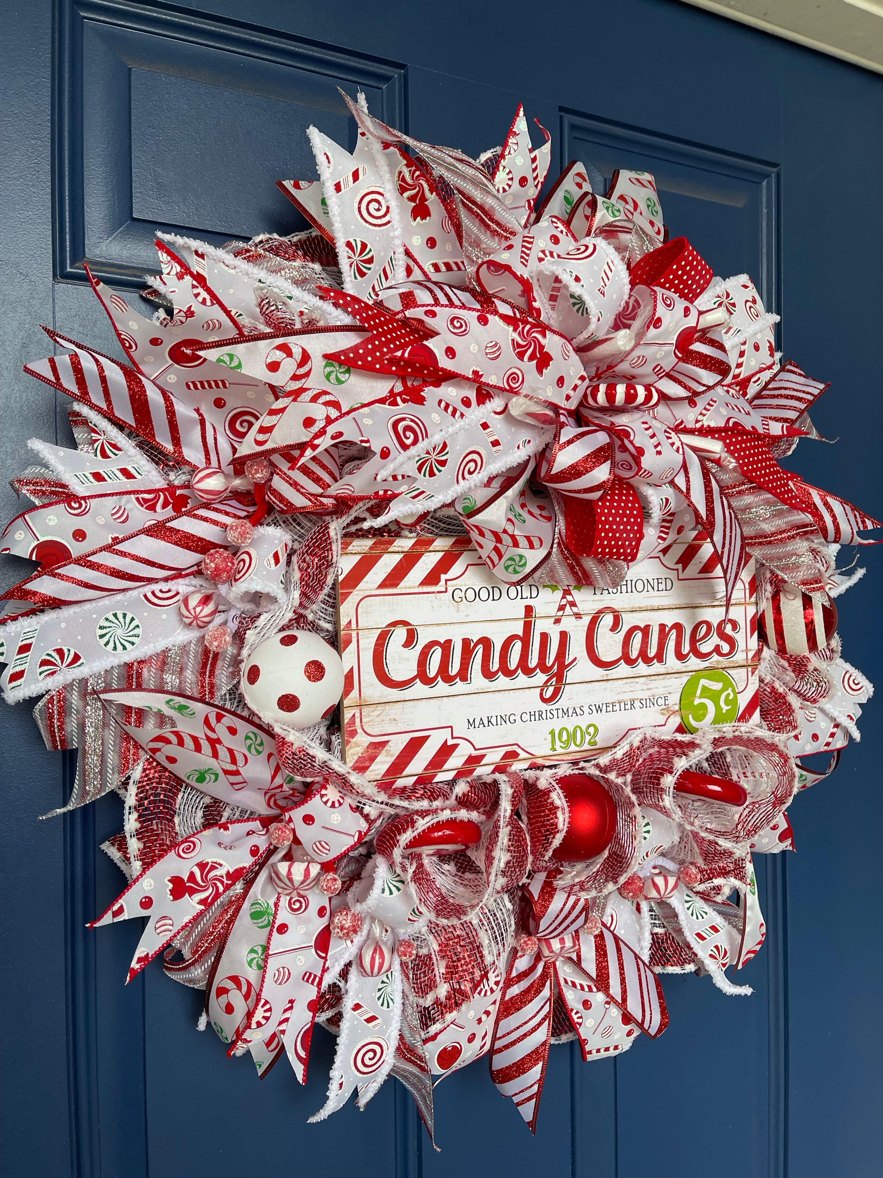 side view of the candy cane Christmas wreath hanging on blue door