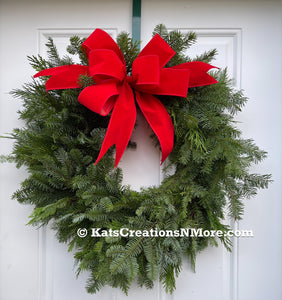 Picture of Fresh Evergreen Wreath with a Velvet Red Bow on a White Door