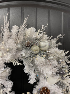 Close Up Detail of White Evergreen Winter Wreath with White Poinsettias, Frosted Pine Cones, Christmas Balls of Silver, White and Gray, along with Silver Glittered Fern and Snow Covered Twigs and 2 White Doves on a Black Door