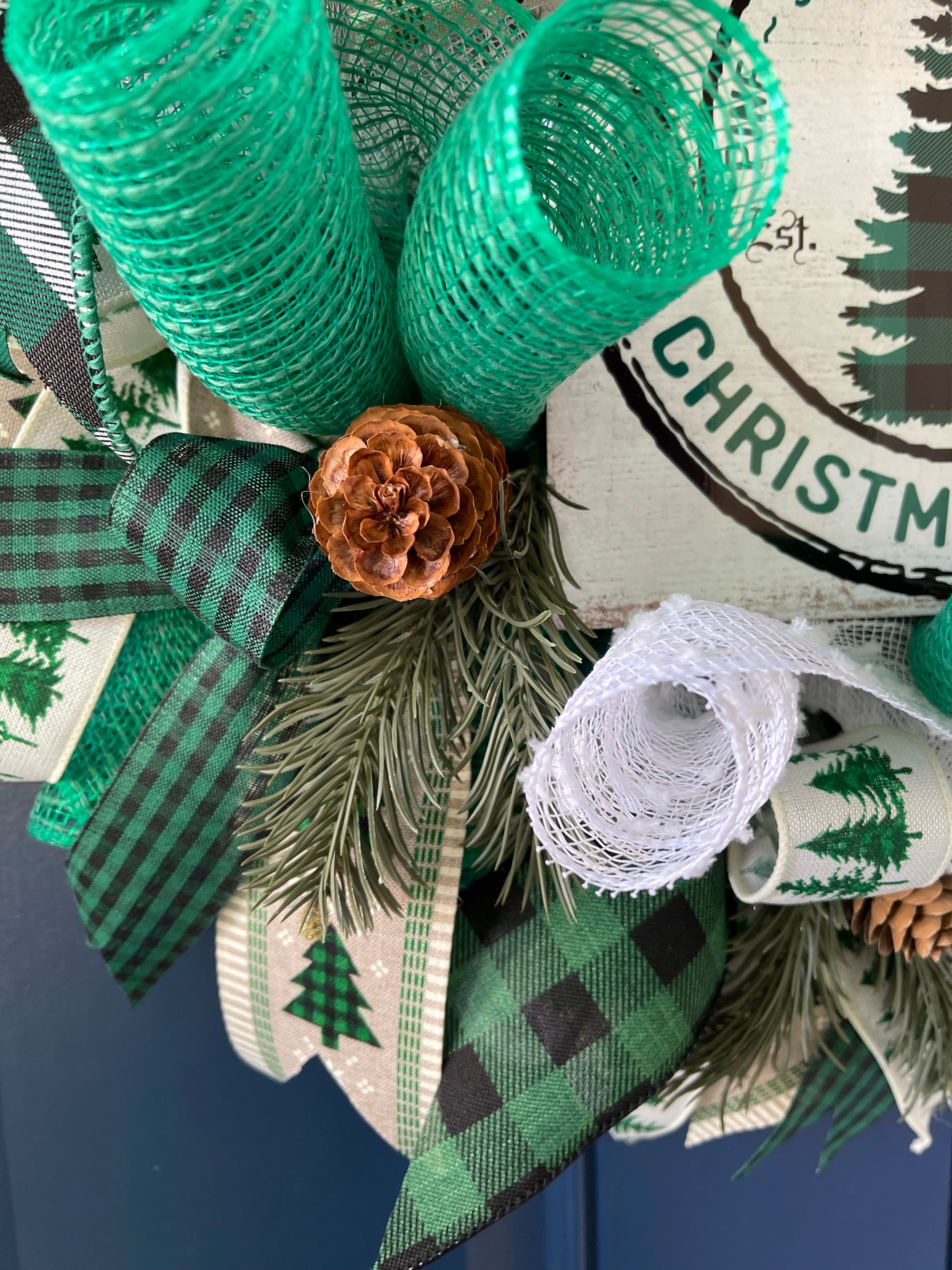 Close Up of Pine Cone with Artificial Pine Branch and Black, White and Green Ribbon