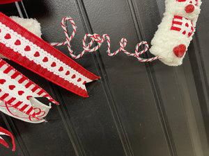 Close up detail of red and white word "Love" in script.