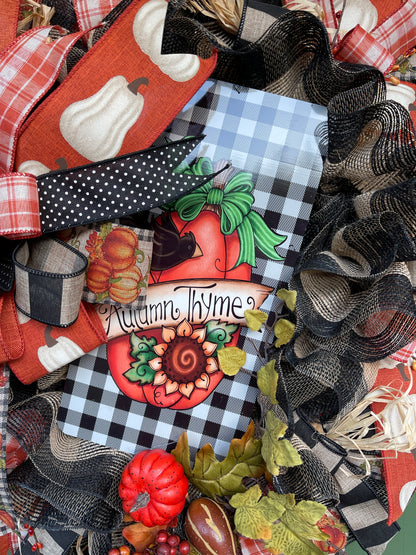 Close Up of Autumn Thyme Sign with Orange Pumpkin with a Sunflower, Black Crow on a Black and White Gingham Print Metal Sign on a Fall Wreath