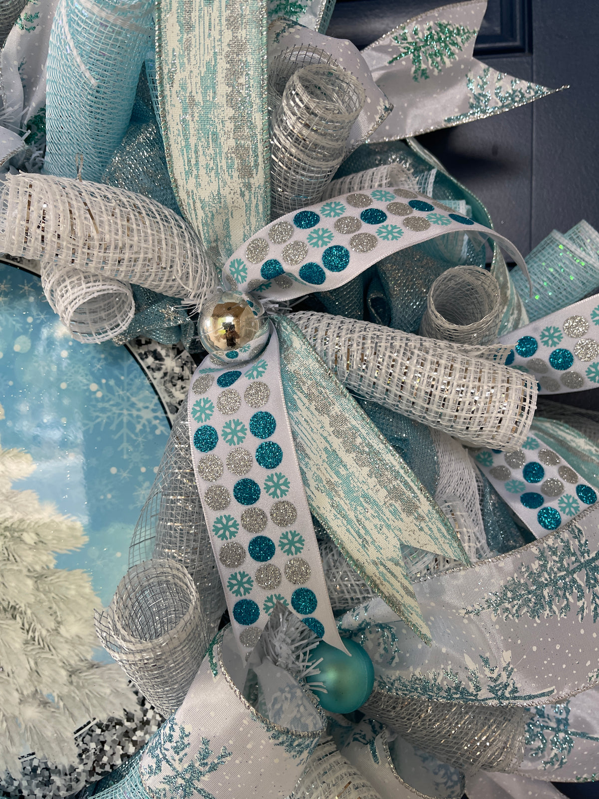Close Up Detail of Blue and Silver Christmas Balls, Blue and White Snowflake Ribbon with Blue Birch Bark Ribbon, Snow Covered Christmas Tree Ribbons and White and Silver Deco Mesh Curls