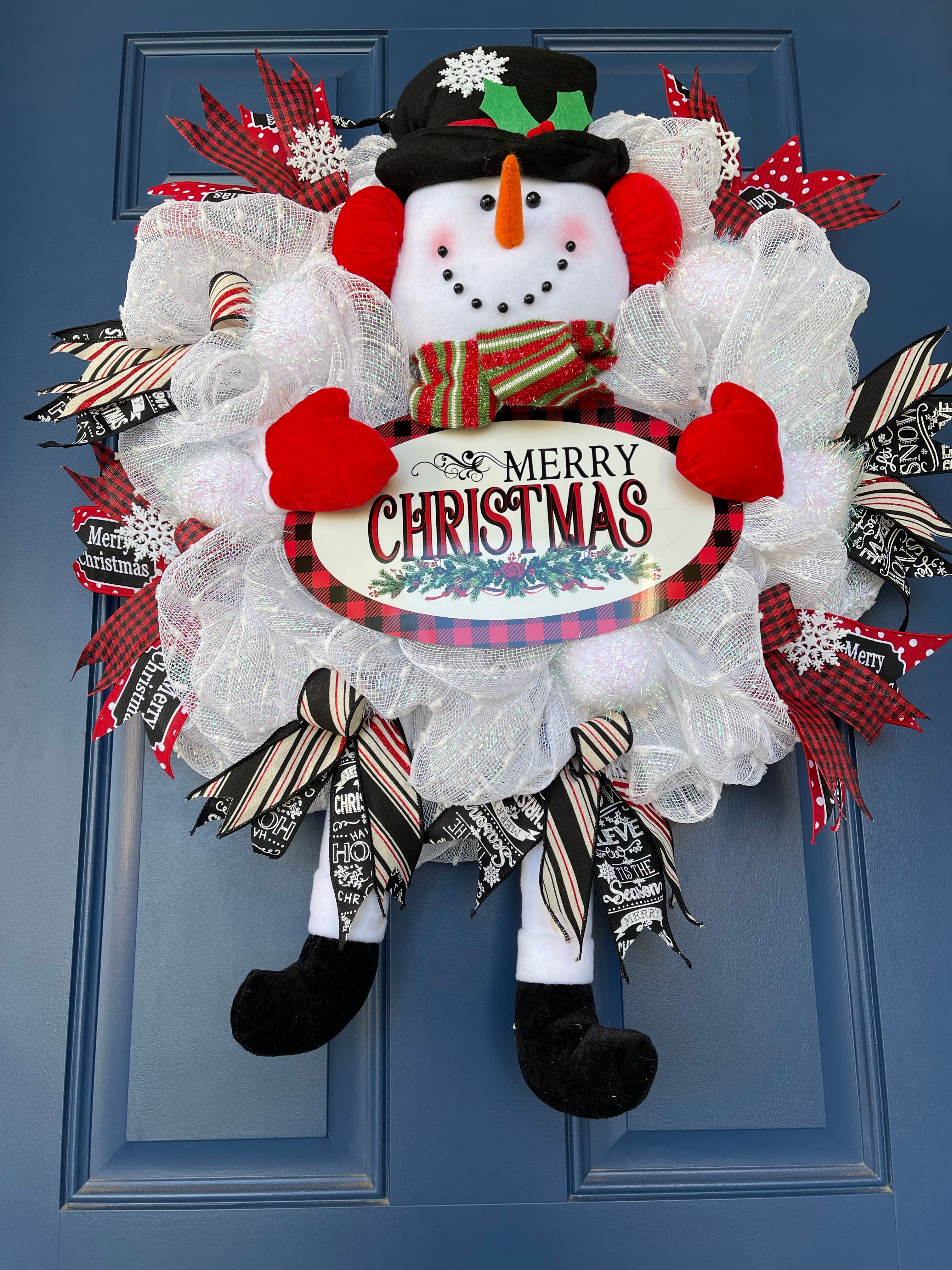 Bottom View of Red, White and Black Snowman Plush Deco Mesh Wreath holding a Merry Christmas Sign on a blue door