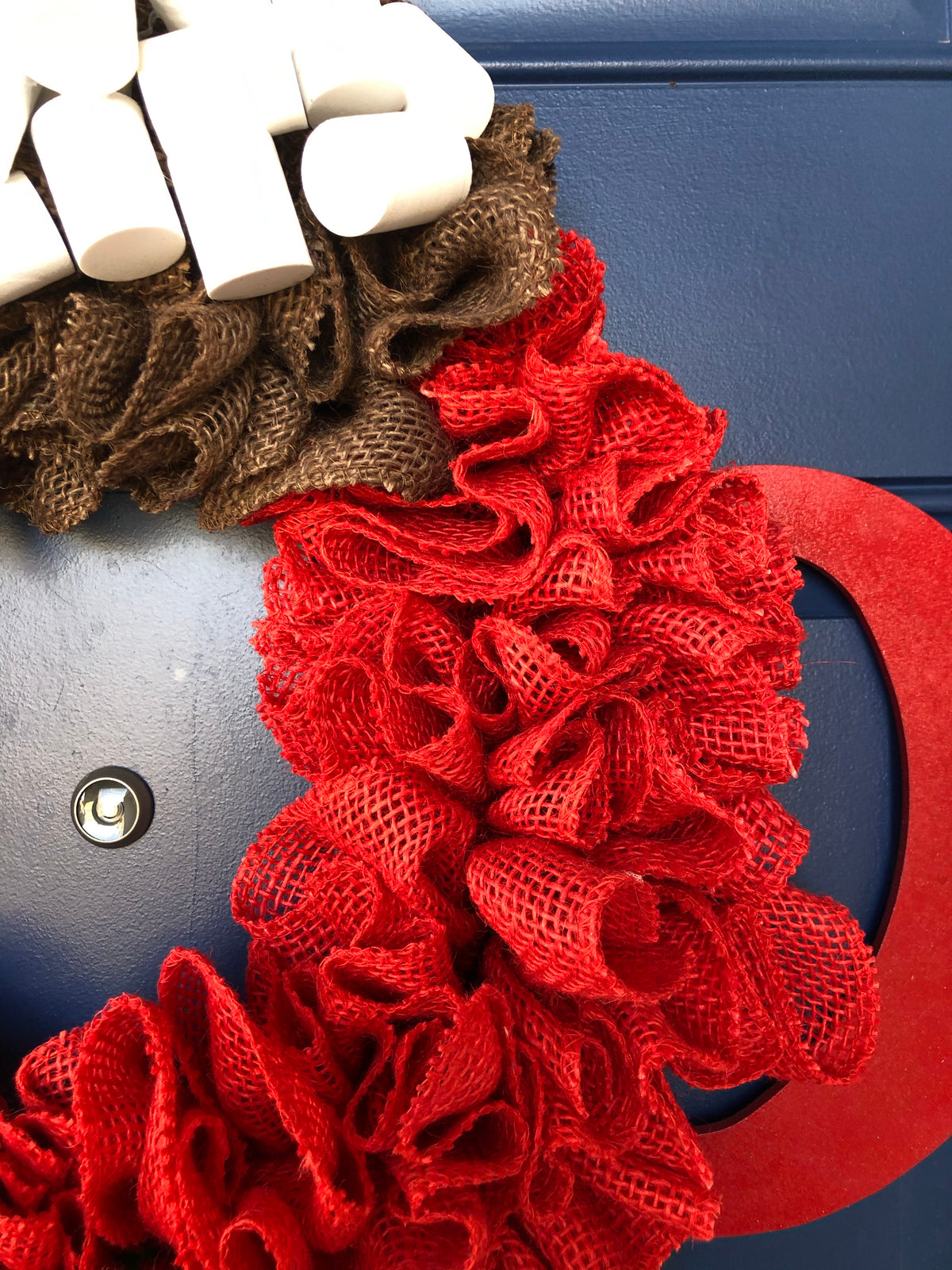 Close up of Red and Brown Burlap, Red Wood Cup Handle and White Foam Marshmallows. 