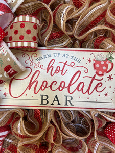 Close Up of Warm Up at the Hot Chocolate Bar Sign with a cup of cocoa with whipped cream and a candy cane.