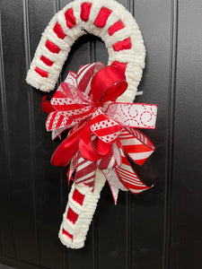 Right Side View of  Red and White Candy Cane Chenille Yarn and Ribbon Christmas Wreath with Red and White Striped Bow for Front Door. 