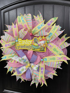 Right Side View of Easter Greetings Bunny Wreath with Pink, Yellow, Blue, Green and Purple Pastel Ribbons and Bows on a Black Door
