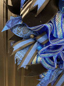 Close Up on Black with Blue Striped Ribbon, along with Police Word Hero Peacemaker Ribbon on a Wreath with Black and Blue Styrofoam Balls