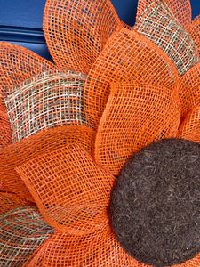 Close up of the Petals of the Poly Burlap Mesh Sunflower Wreath Featuring Orange and Patterned Colors of Yellow, Brown and Orange with a Brown Center on a Blue Door
