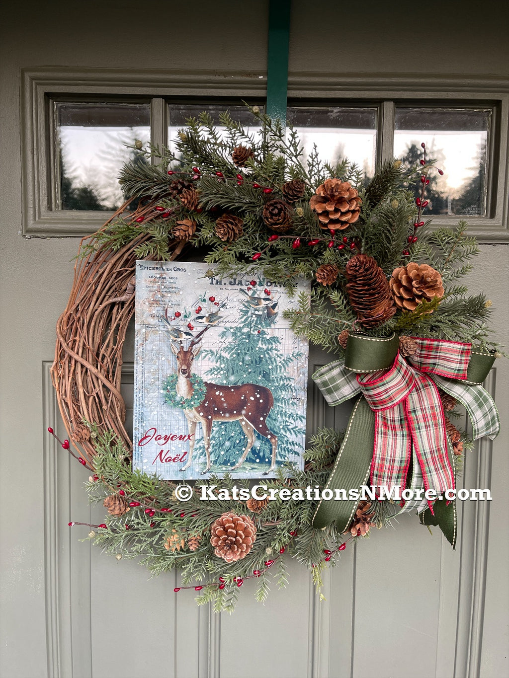Winter Deer Grapevine Pine and Pine Cones Wreath with a Red, White and Green Bow on a Green Door