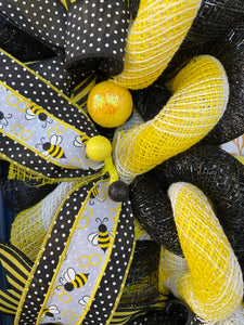 Close Up of Yellow Styrofoam balls on Ribbon with Black, White and Yellow Bumble Bees and Black and White Polka Dot Ribbon