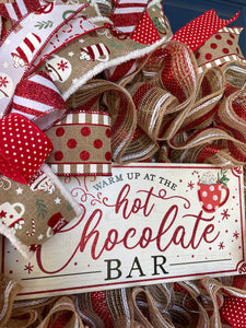 Close Up of Warm Up at the Hot Chocolate Bar Sign with a cup of cocoa with whipped cream and a candy cane.