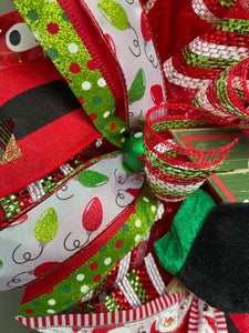 Close Up Details of Ribbon with Green and Red Christmas Bulbs on White with a Green Ribbon with Red, White and Green Polka Dots with a small Green Christmas Ball with Polka Dots in the center
