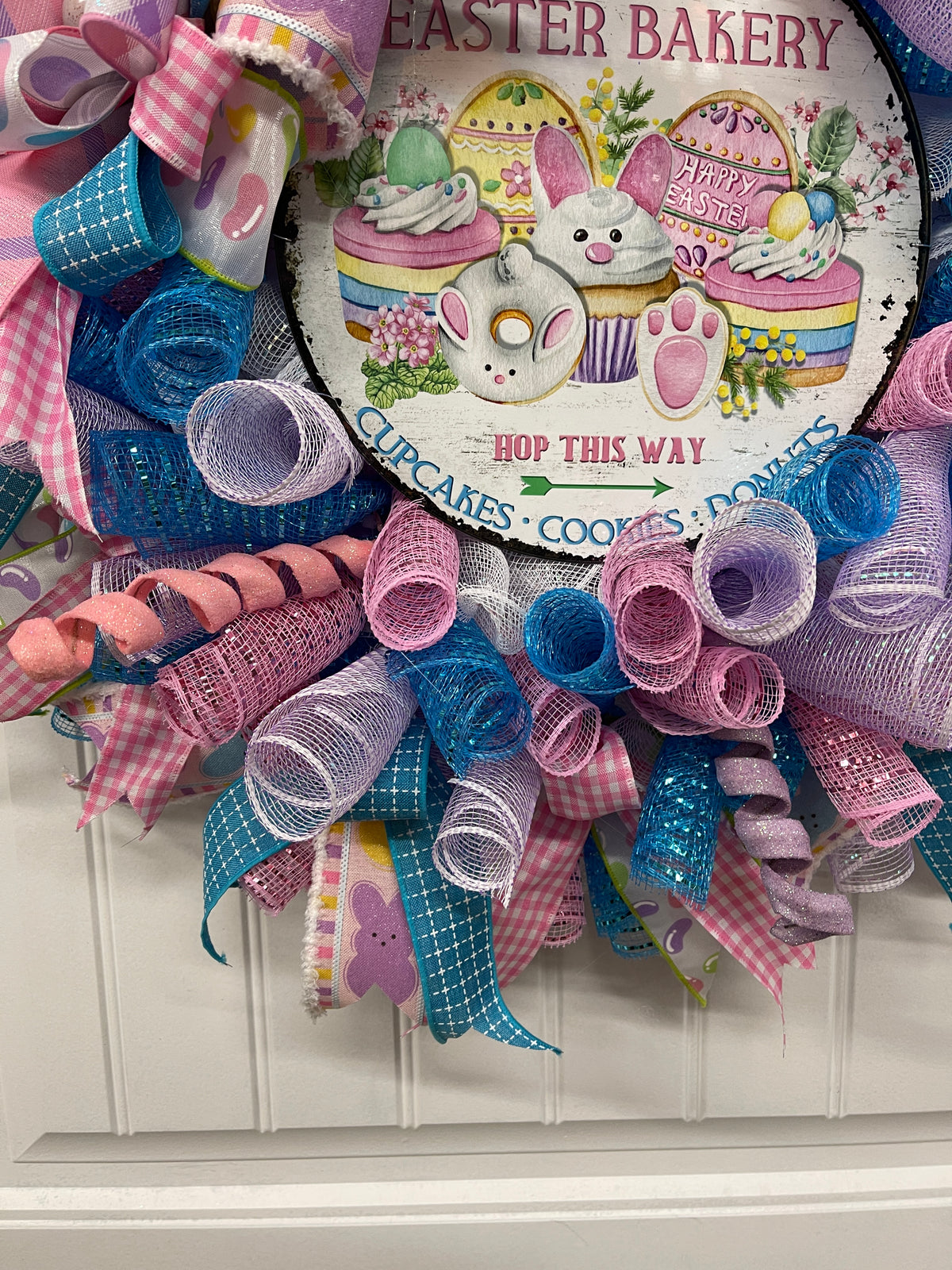 Close up on pastel Deco Mesh Curls of Pink, Blue, White and Purple on an Easter Bakery Wreath